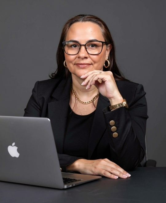 Foto de uma advogada sorrindo e usando terno, representando a Cristina Rocha de Oliveira Advogada, na seção inicial da landing page.